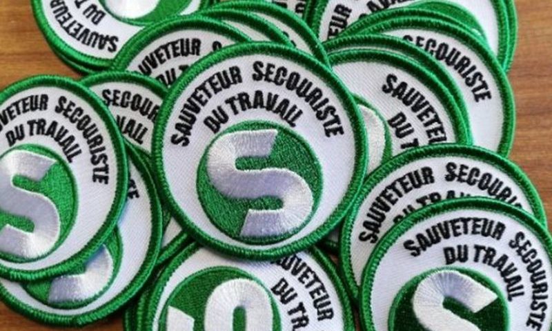 Une dizaine de macaron sst et ecusson secouriste verts réalisés par brod'art.